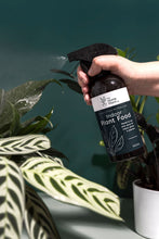 Load image into Gallery viewer, A person is holding The Home Plant Co foliar spray bottle and spraying plant foliage
